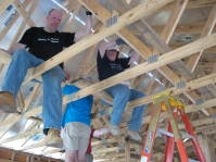 Picture of building crew sitting on new roof beams.